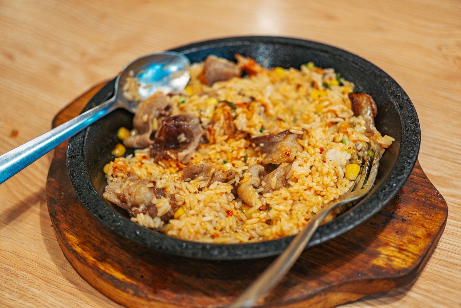 Fried rice with meat and vegetables on a wooden board