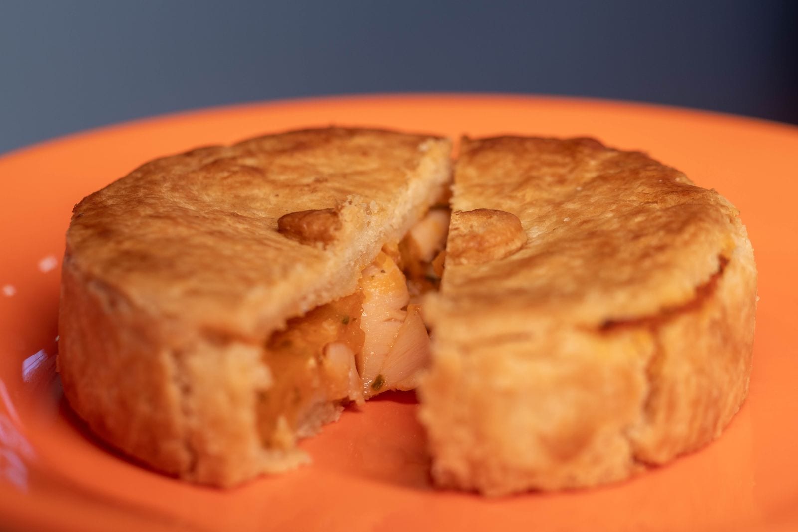 A savoury pot pie with a slice cut out, showing the creamy filling