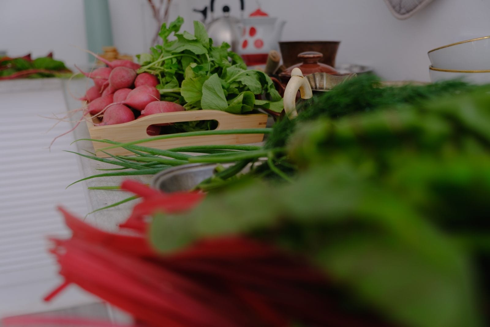 Fresh radishes and greens laid out on a kitchen counter